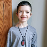 Boy wears red scorpion chew necklace