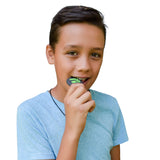 Teen boy chewing on green and black Dino skull chewelry.