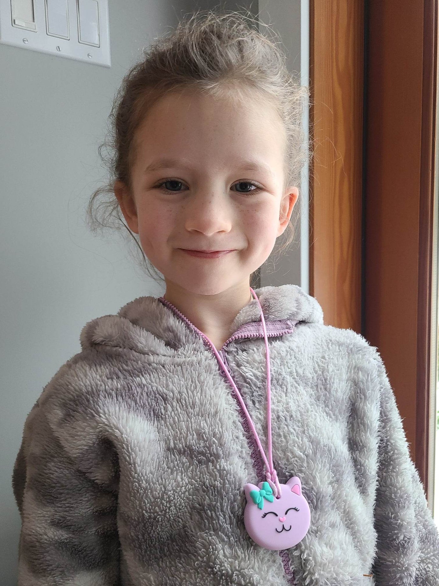 Munchables founder’s daughter modelling the patented purple cat sensory chew necklace for mild to moderate chewers.