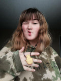 Woman wears gold hamsa hand chewelry necklace