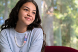 Teenage girl wears Munchables Pearl Roses Necklace.