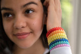 Teenager wears all 7 rainbow coloured Munchables Stretchy Coil Fidget Bracelets