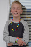 Munchables Rainbow Chew Necklace worn by a young boy.