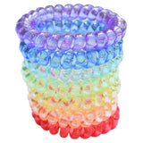Stack of rainbow coloured Munchables coil bracelet stim toys