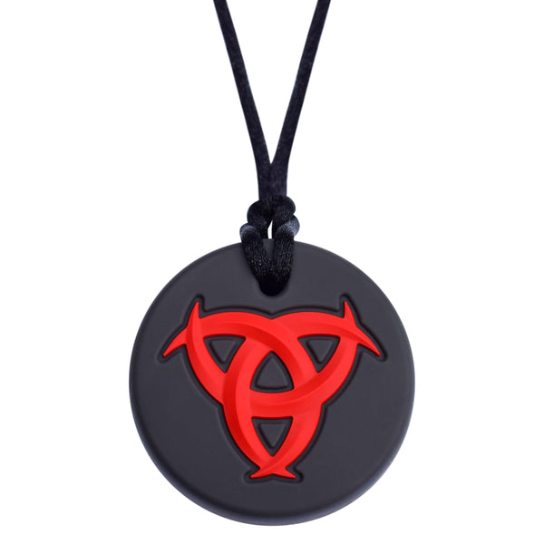 Munchables Celtic Chew Necklace with black background and red, raised design. 