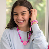 Girl wearing Munchables Starlight Chewelry in fuchsia/pink/purple.