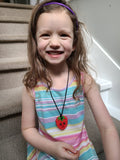 Girl wears Munchables Strawberry Chew Necklace