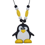 Munchables Mr. Penguin Chew Necklace in yellow, black and white. Features beads on either side of the black cord that it is strung on. 