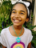 Munchables Baby Owl chewable stim worn by smiling preteen girl.