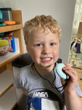 Young boy holding blue donut oral motor aid in Los Angeles, California, USA