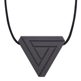 An adult chew necklace in the shape of a triangle with smaller inset geometric triangles on the front-side. Shown in a charcoal colour on a black cord.